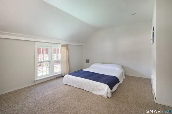 a spacious bedroom with a bed and a window