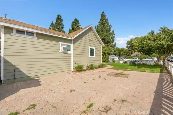 a view of a house with a yard and potted plants