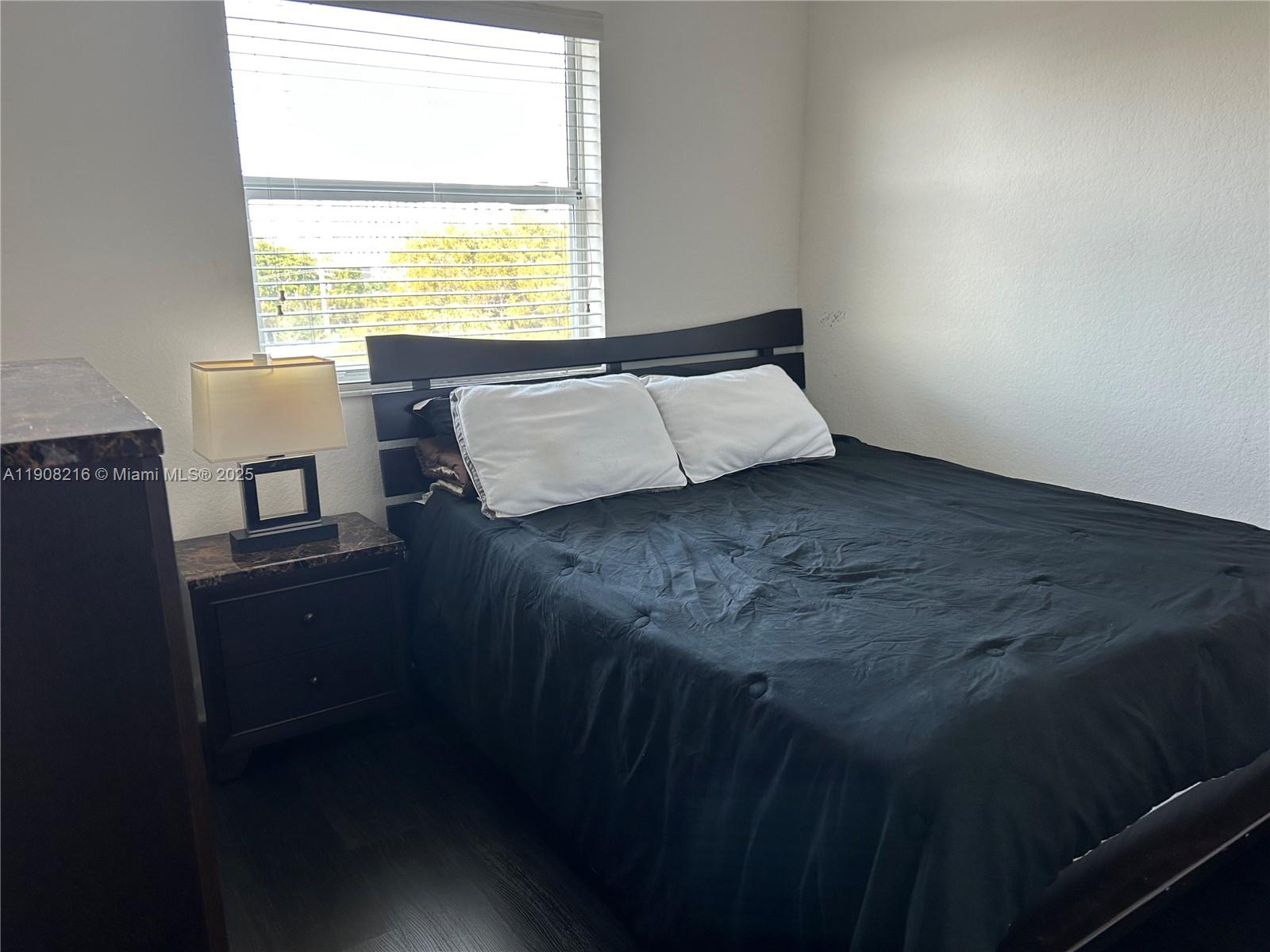 6001 Southwest 70th Street, Unit 551 South Miami, FL 33143 - Photo 9 of 23 a bed sitting in a bedroom next to a window