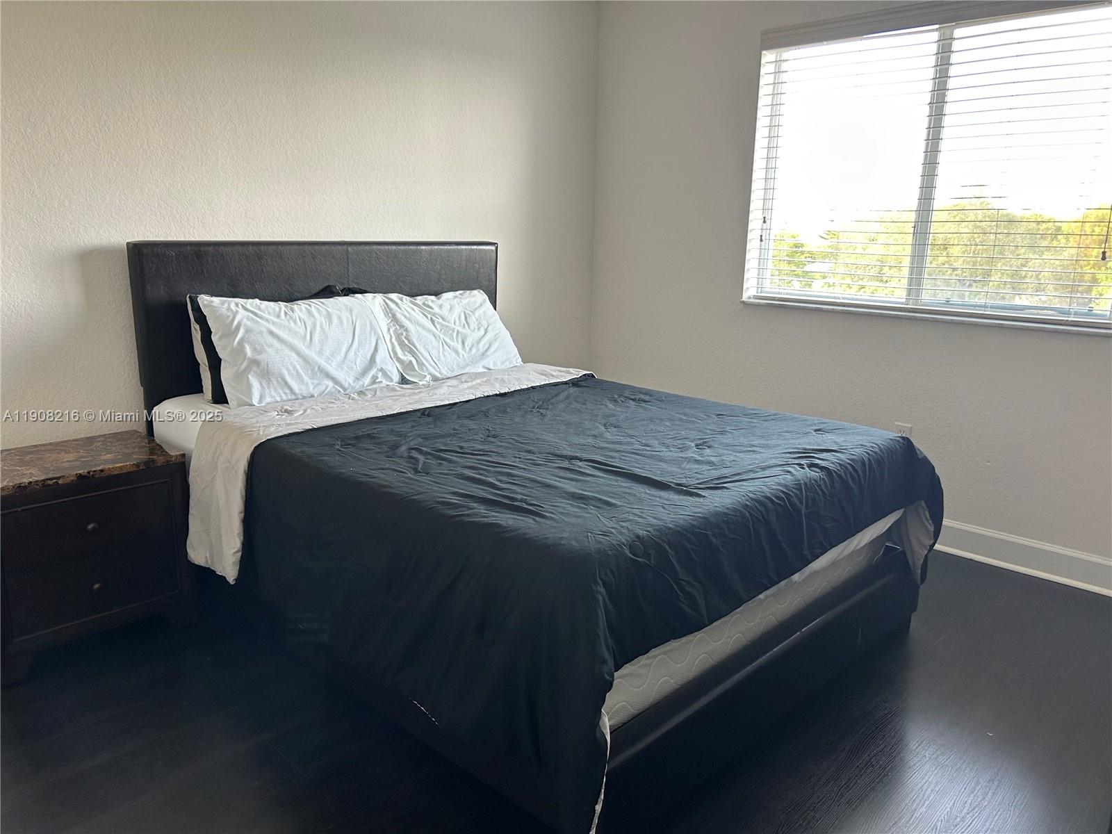 6001 Southwest 70th Street, Unit 551 South Miami, FL 33143 - Photo 10 of 23 a bed sitting in a bedroom next to a window