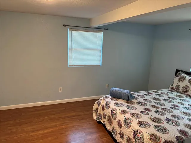 a bedroom with a bed and wooden floor