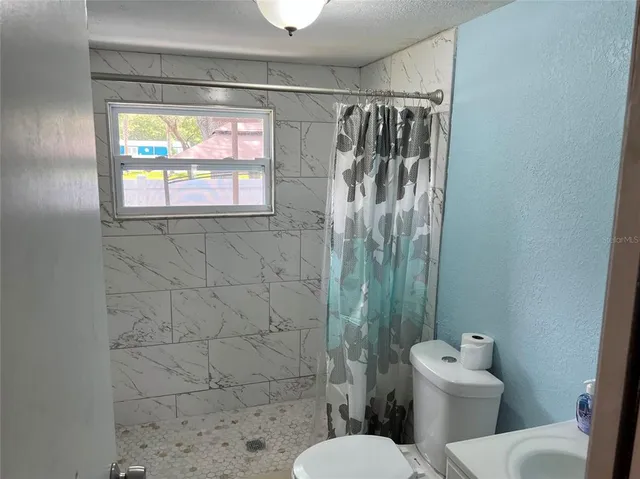 a bathroom with a toilet sink and shower