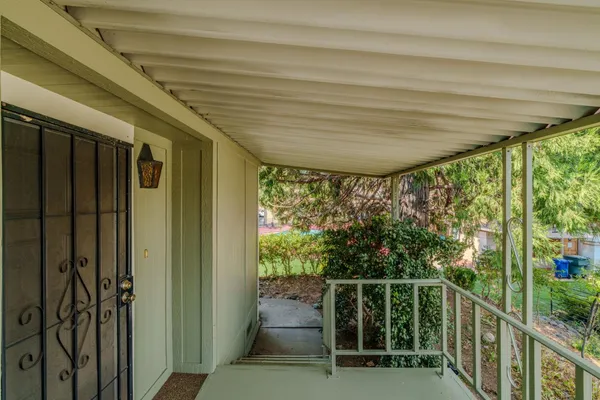 an empty room with ceiling fan and windows