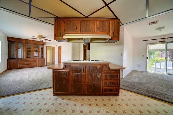 a view of an empty room with a fireplace and windows