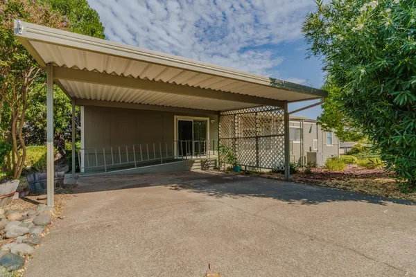 a view of a house with a patio and a yard