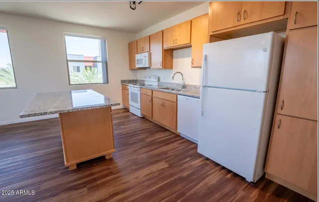 a kitchen with wooden floors and white appliances
