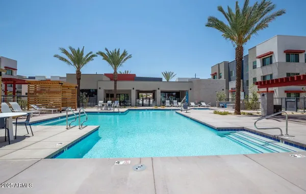 a swimming pool with outdoor seating and a garden