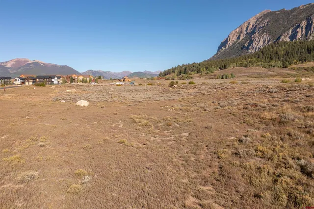 a view of a dry yard with mountains in the background