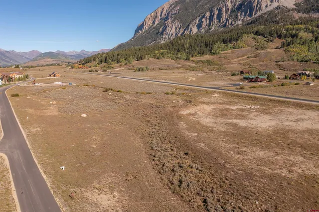 a view of a lake with mountain and car parked