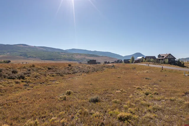 a view of a large mountain with sunset in background