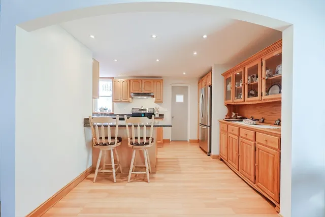 a kitchen with stainless steel appliances kitchen island granite countertop a stove a sink and a cabinets