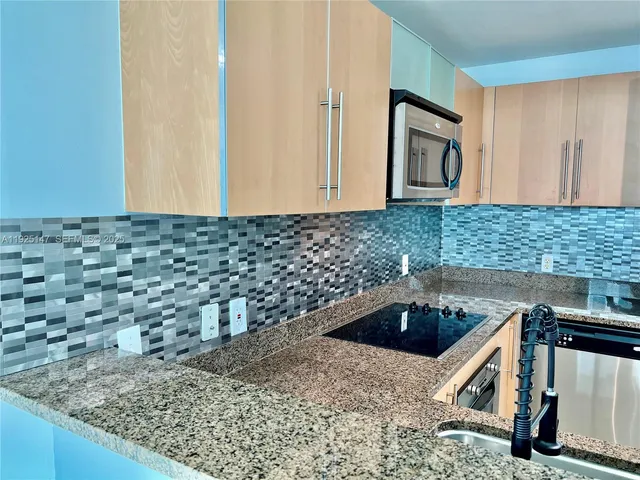 a kitchen with a sink a stove and cabinets