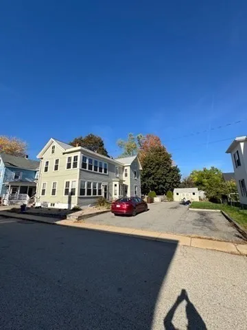 a front view of a building with cars parked