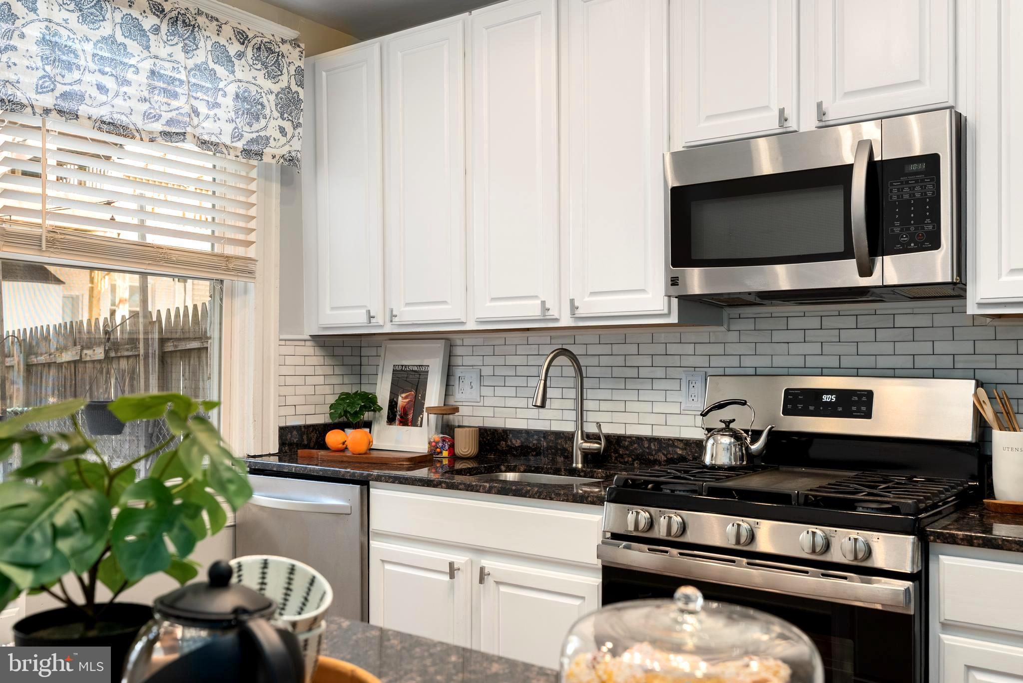 280 South Robinson Street Baltimore, MD 21224 - Photo 16 of 40 a kitchen with stainless steel appliances a stove a sink a microwave and cabinets