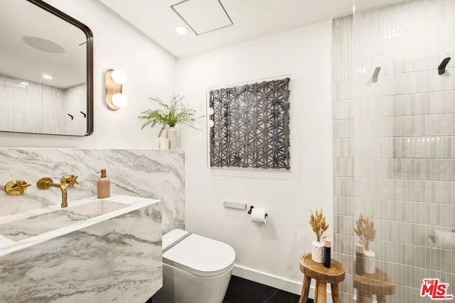 a bathroom with a toilet sink and mirror