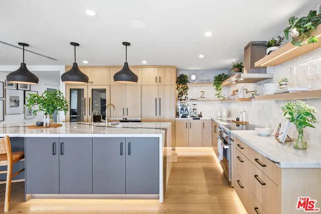 a kitchen with kitchen island granite countertop a sink stainless steel appliances and cabinets