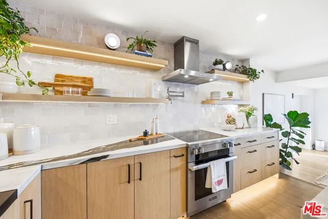 a kitchen with stainless steel appliances granite countertop a sink a stove and cabinets