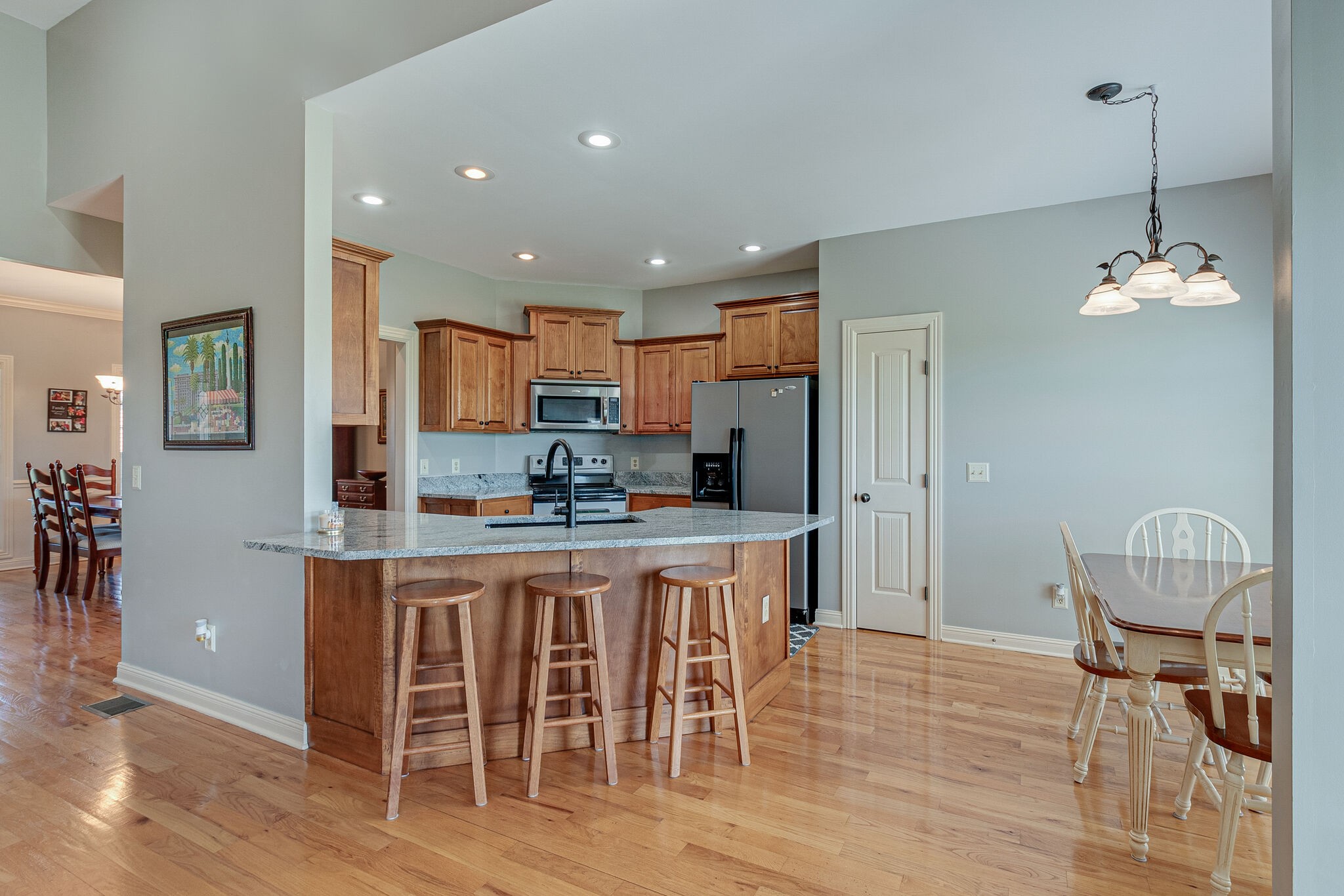 1586 Maxwell Branch Road Cottontown, TN 37048 - Photo 13 of 32 a kitchen with stainless steel appliances granite countertop a table chairs and a refrigerator