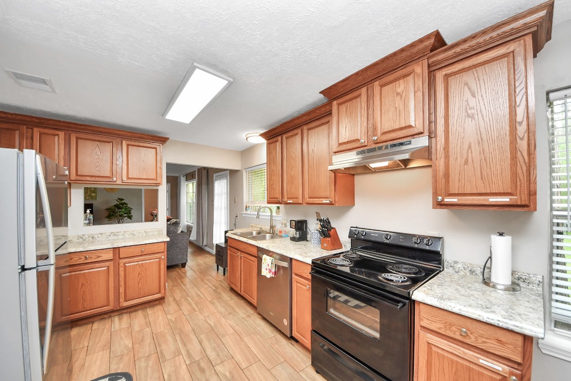 25803 Timber Lakes Drive Spring, TX 77380 - Photo 21 of 48 a kitchen with stainless steel appliances granite countertop a stove sink and cabinets