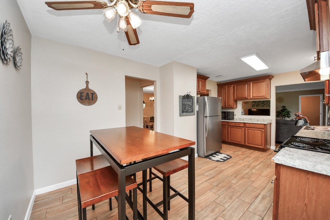 25803 Timber Lakes Drive Spring, TX 77380 - Photo 23 of 48 a kitchen with stainless steel appliances kitchen island a table chairs and a refrigerator