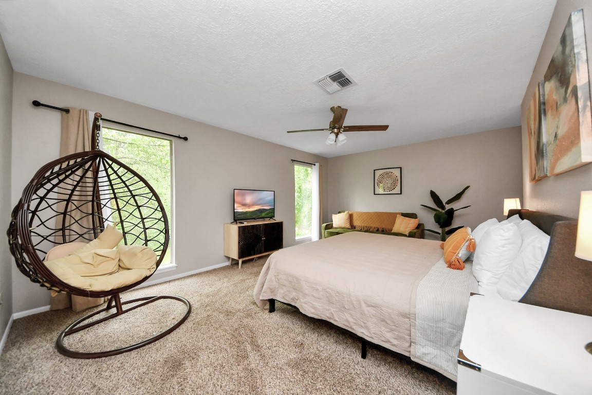 25803 Timber Lakes Drive Spring, TX 77380 - Photo 36 of 48 a bedroom with a bed a chandelier and dresser