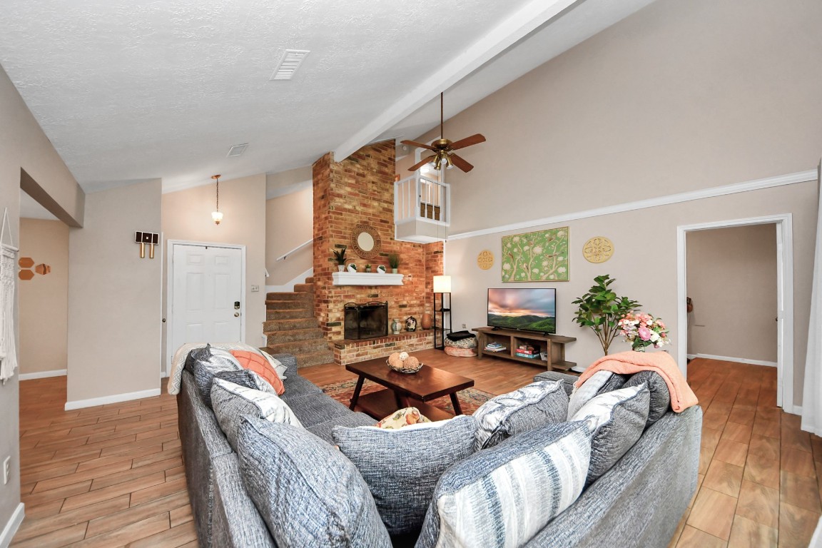 25803 Timber Lakes Drive Spring, TX 77380 - Photo 6 of 48 a living room with furniture a fireplace and a chandelier