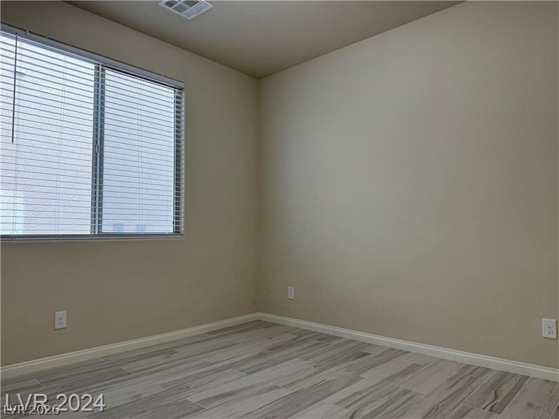 9056 Tony Ridge Avenue Las Vegas, NV 89148 - Photo 23 of 32 A well-lit bedroom with modern flooring offers a serene and versatile living space.