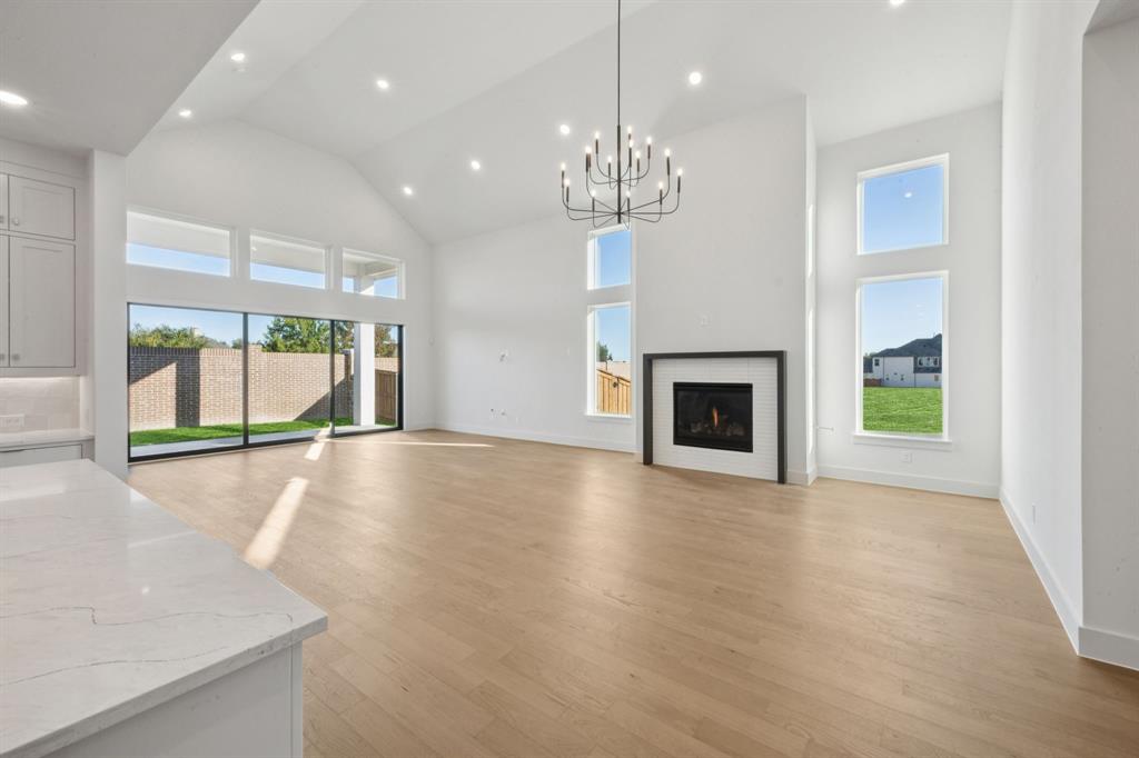 2124 Wakefield Lane Allen, TX 75013 - Photo 5 of 18 a view of an empty room with a fireplace and a window