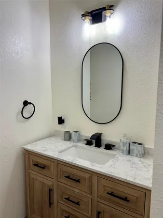 a bathroom with a granite countertop double vanity sink and a mirror
