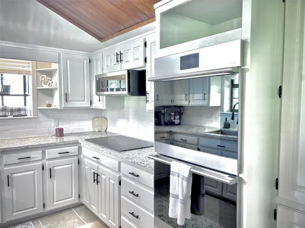 a kitchen with stainless steel appliances granite countertop a sink and cabinets
