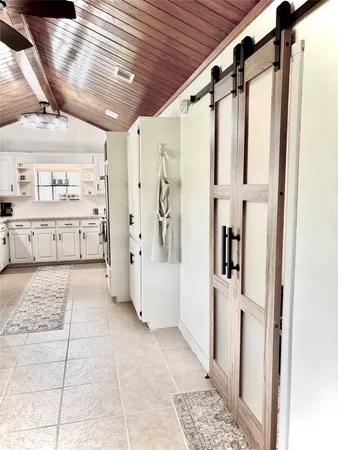 a kitchen with a refrigerator and white cabinets