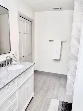a bathroom with a granite countertop sink and a mirror