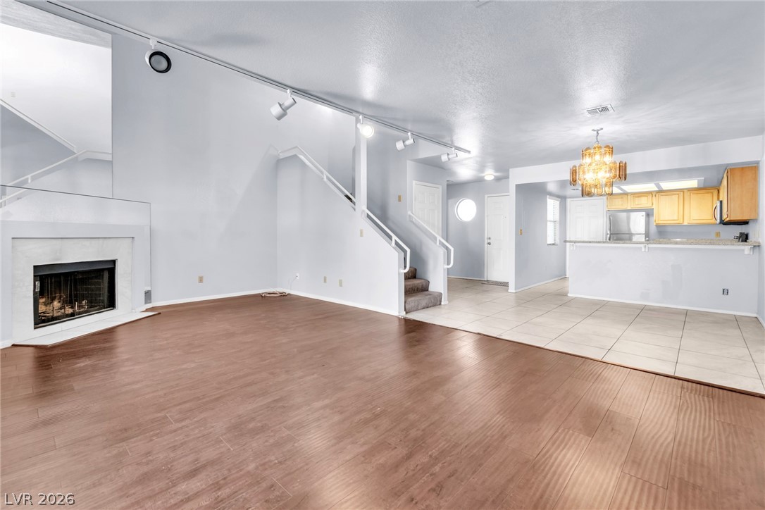 6250 West Flamingo Road, Unit 98 Las Vegas, NV 89103 - Photo 13 of 40 Unfurnished living room with a textured ceiling, visible vents, a chandelier, and light wood-type flooring