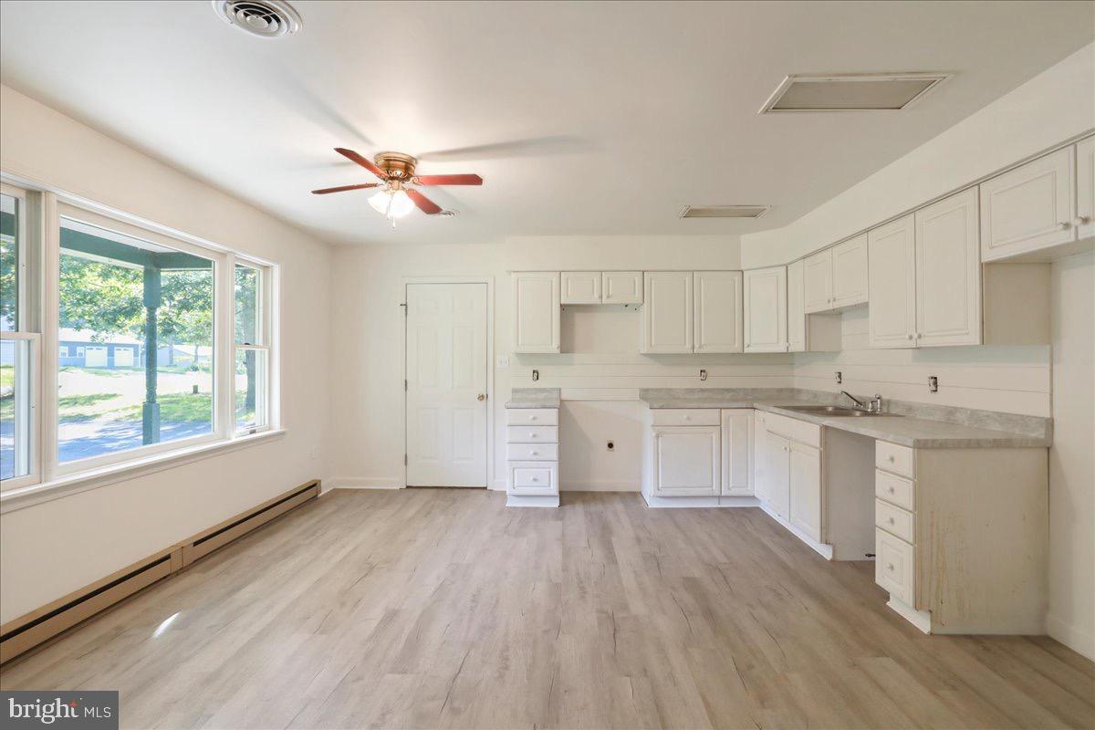 246 Poets Lane Inwood, WV 25428 - Photo 17 of 32 a kitchen with granite countertop a stove a sink and white cabinets with wooden floor