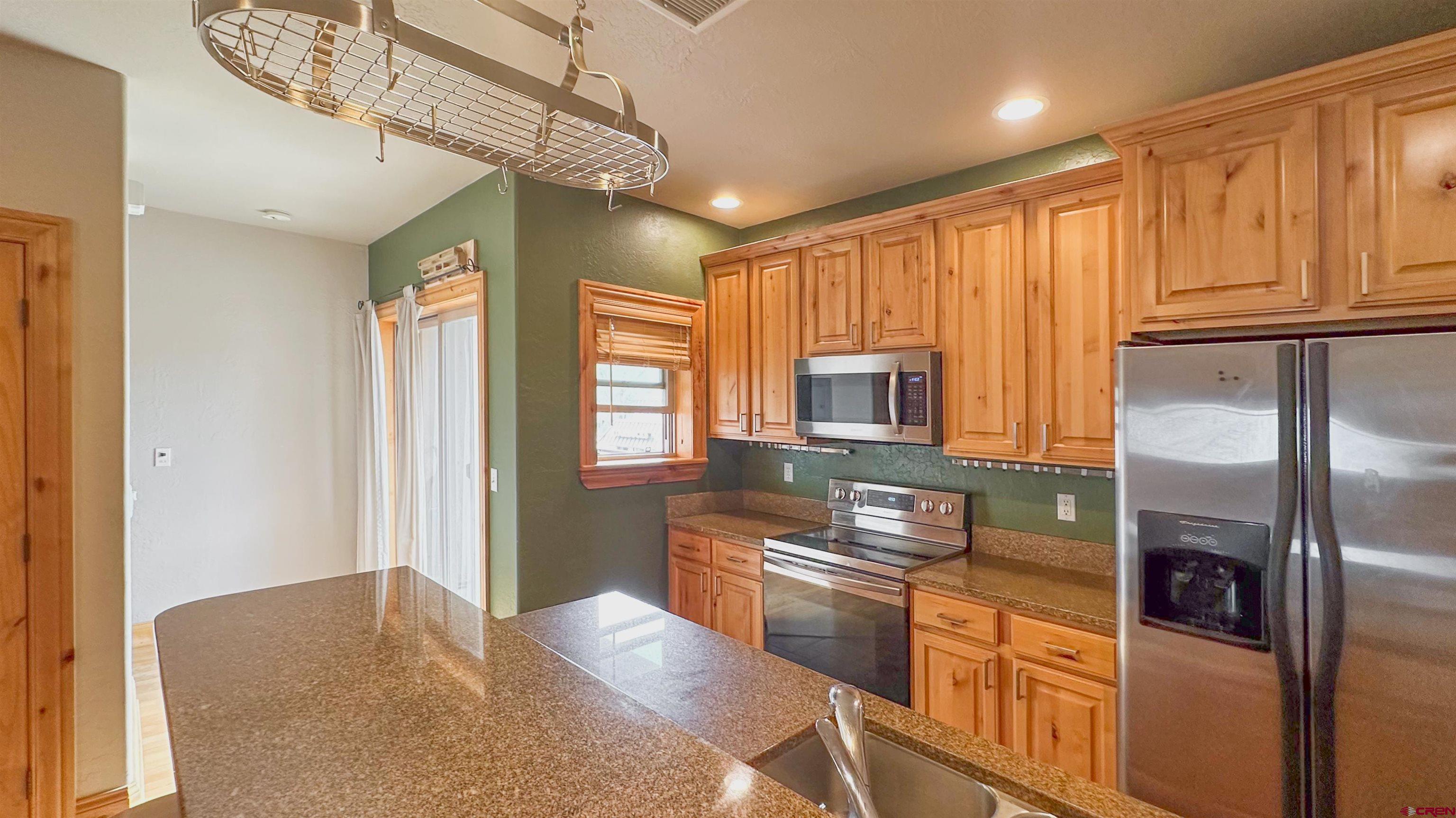 2855 Main Avenue, Unit A 209 Durango, CO 81301 - Photo 5 of 20 a kitchen with stainless steel appliances granite countertop a refrigerator a stove a sink and a microwave