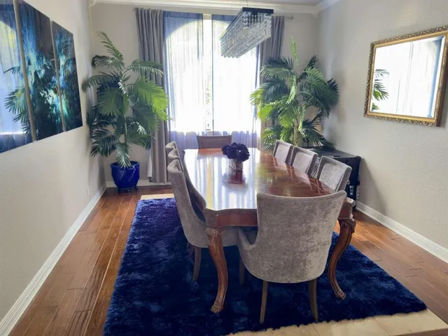 a dining room with furniture potted plants and wooden floor