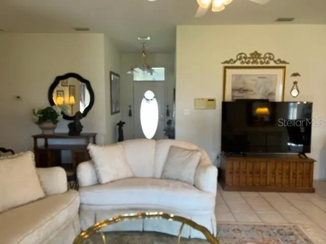 a living room with furniture a mirror and a chandelier