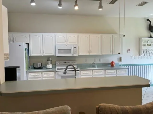 a large kitchen with stainless steel appliances a stove a sink and a refrigerator