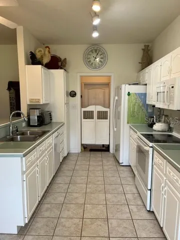 a kitchen with a sink and a large mirror