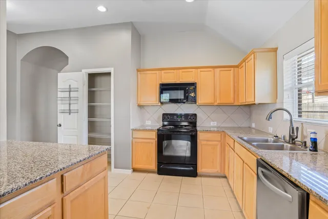 a kitchen with stainless steel appliances granite countertop a stove sink and cabinets