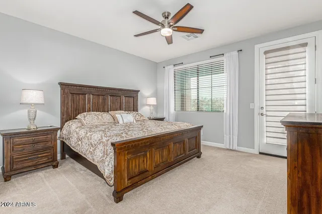 a bed sitting in a bedroom next to a window and a chandelier