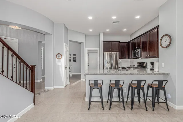 a kitchen with stainless steel appliances granite countertop a stove a sink a refrigerator and a cabinets