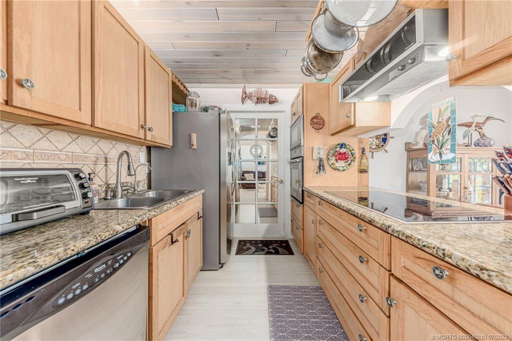 4171 Southeast Robert Loop Road Stuart, FL 34997 - Photo 11 of 27 a kitchen with granite countertop stainless steel appliances and sink