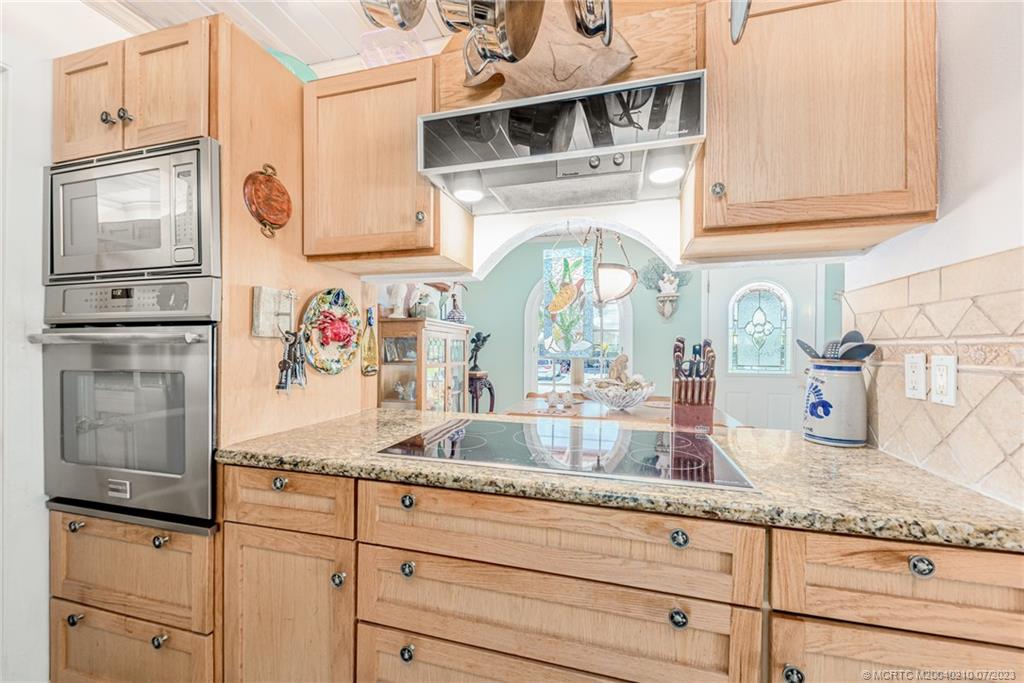 4171 Southeast Robert Loop Road Stuart, FL 34997 - Photo 12 of 27 a kitchen with granite countertop white cabinets and stainless steel appliances