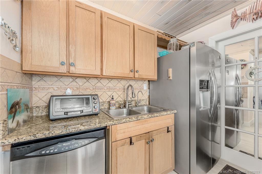 4171 Southeast Robert Loop Road Stuart, FL 34997 - Photo 13 of 27 a kitchen with stainless steel appliances granite countertop a refrigerator and a counter space