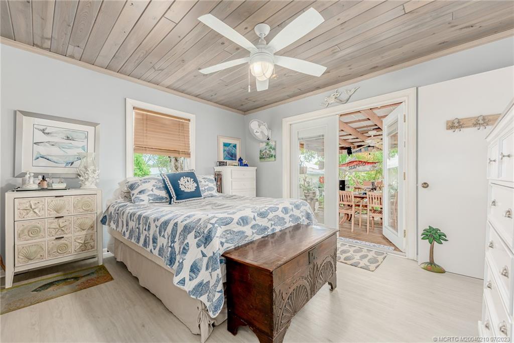 4171 Southeast Robert Loop Road Stuart, FL 34997 - Photo 14 of 27 a bedroom with a large bed and a chandelier