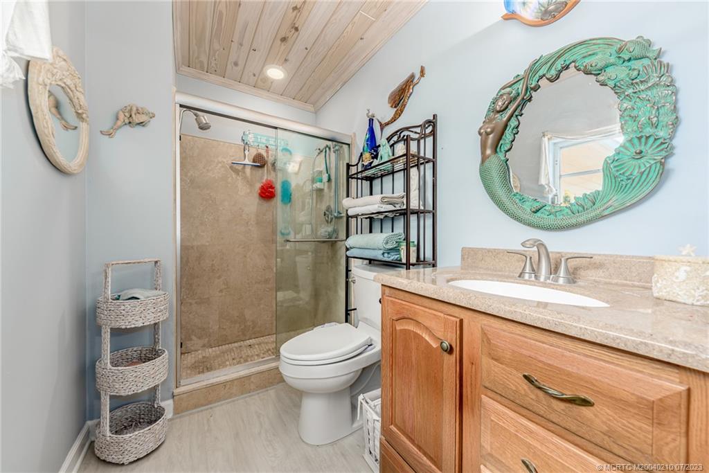 4171 Southeast Robert Loop Road Stuart, FL 34997 - Photo 17 of 27 a bathroom with a granite countertop toilet sink and mirror