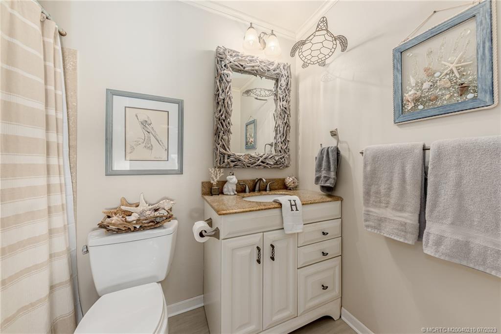 4171 Southeast Robert Loop Road Stuart, FL 34997 - Photo 19 of 27 a bathroom with a sink vanity mirror and toilet