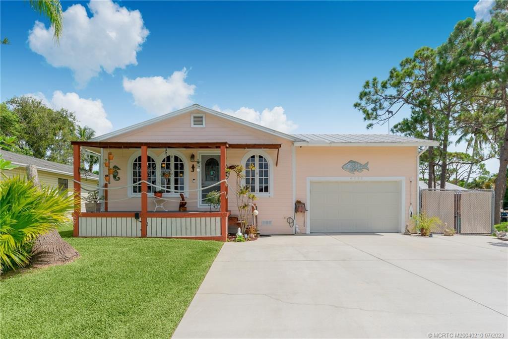 4171 Southeast Robert Loop Road Stuart, FL 34997 - Photo 2 of 27 a front view of a house with a garden and pathway