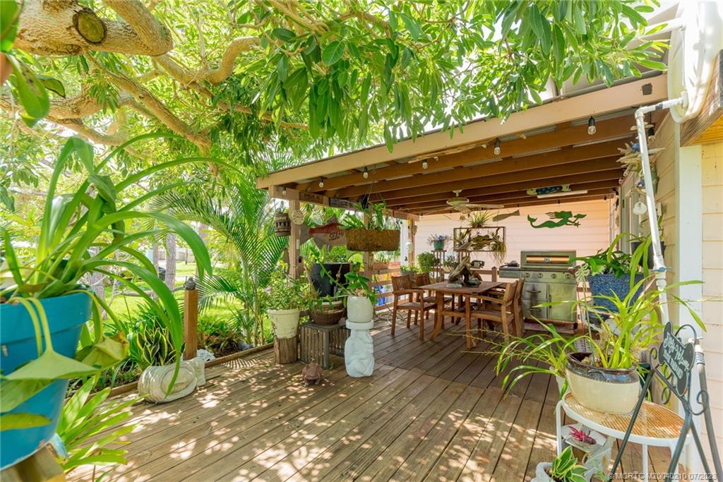 4171 Southeast Robert Loop Road Stuart, FL 34997 - Photo 22 of 27 a view of a patio with table and chairs potted plants and floor to ceiling window